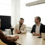 A diverse group of business professionals engaged in a meeting in an office setting.